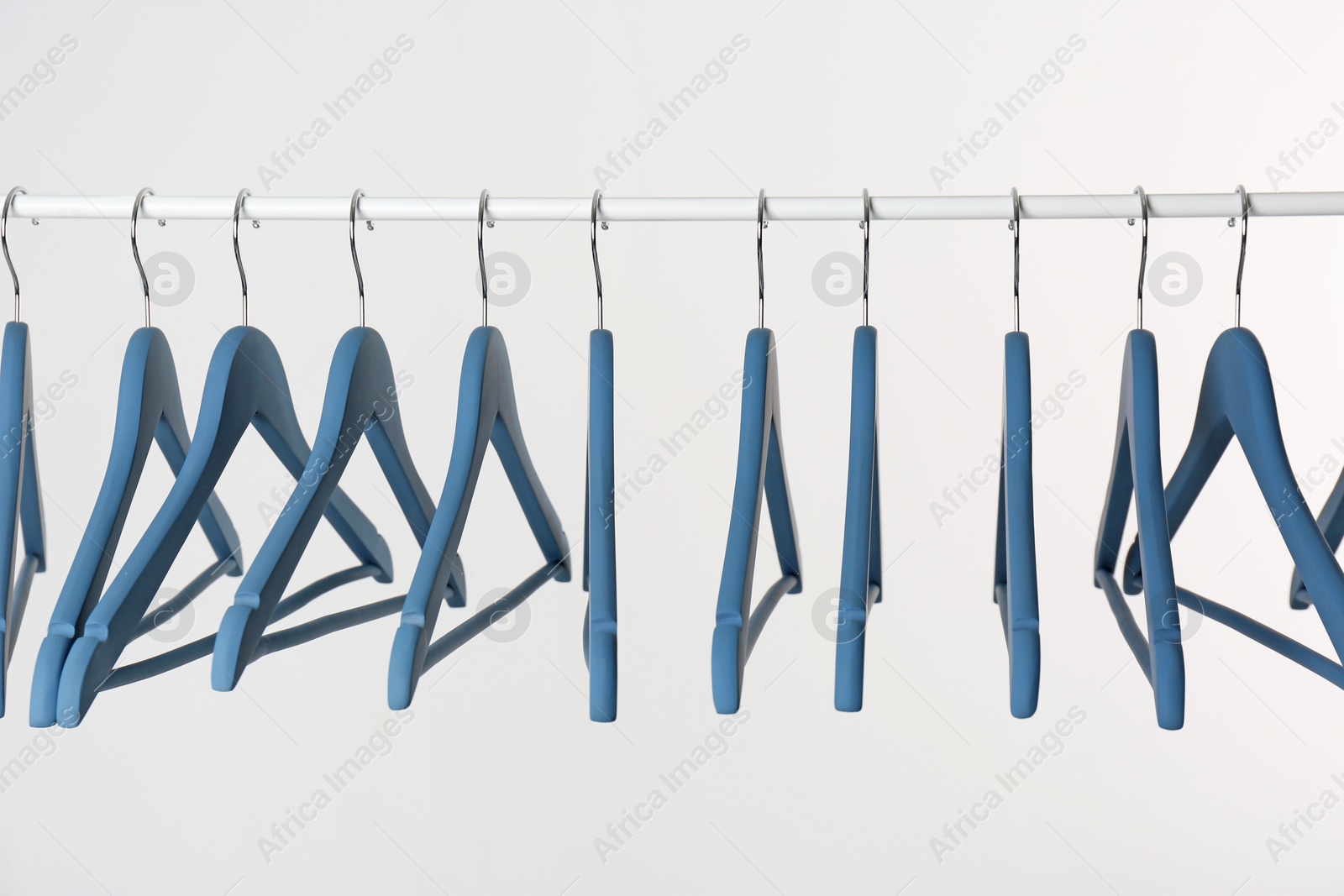 Photo of Metal rack with clothes hangers on white background