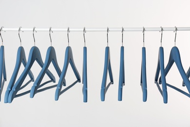 Photo of Metal rack with clothes hangers on white background