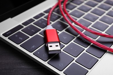 Red USB cable on laptop keyboard, closeup