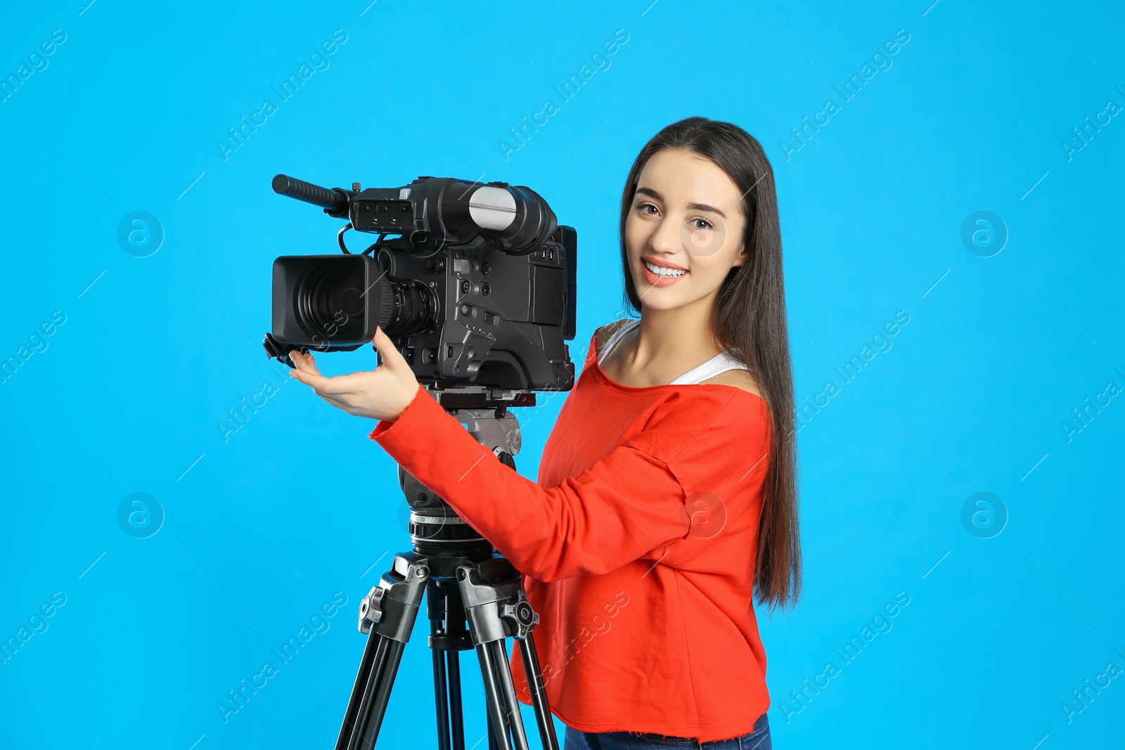 Photo of Operator with professional video camera on blue background