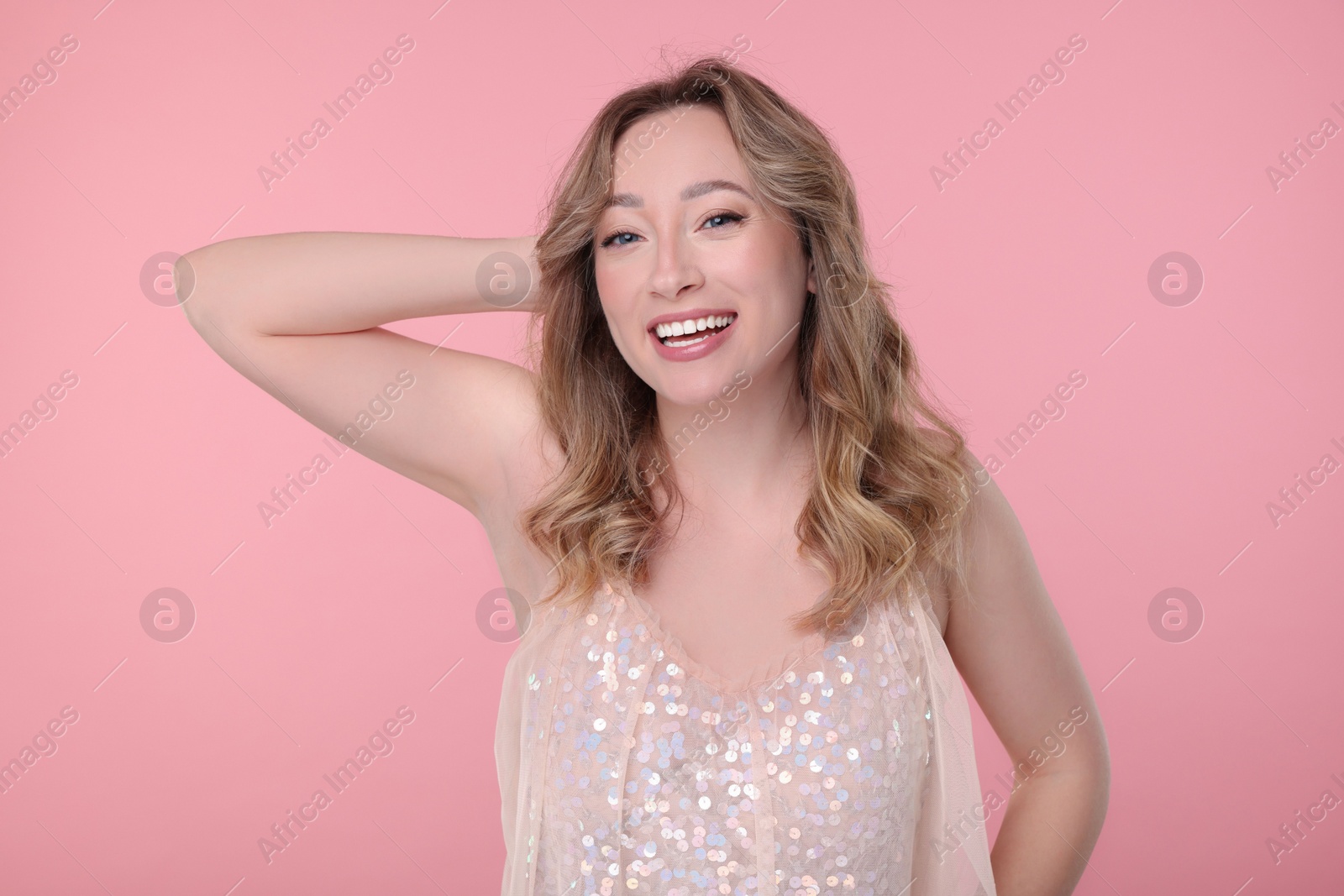 Photo of Portrait of smiling woman on pink background