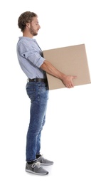 Photo of Full length portrait of young man carrying heavy cardboard box on white background. Posture concept