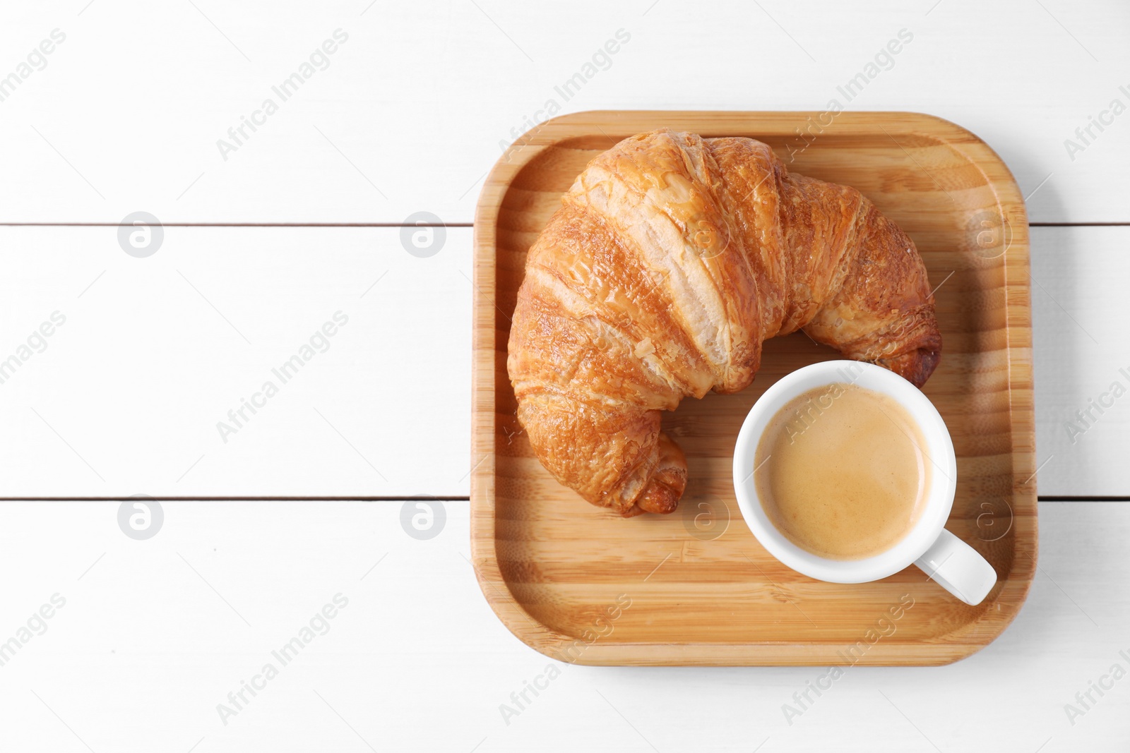 Photo of Breakfast time. Fresh croissant and coffee on white wooden table, top view. Space for text