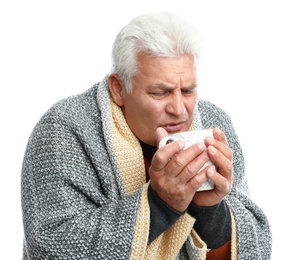 Photo of Mature man with cup of hot beverage suffering from cold on white background