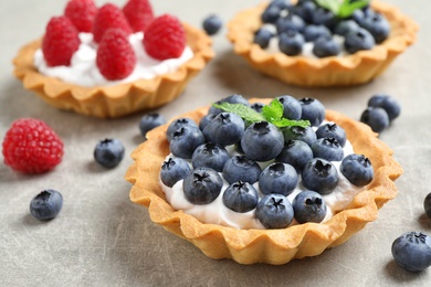 Photo of Delicious sweet pastry with berries on grey table, closeup