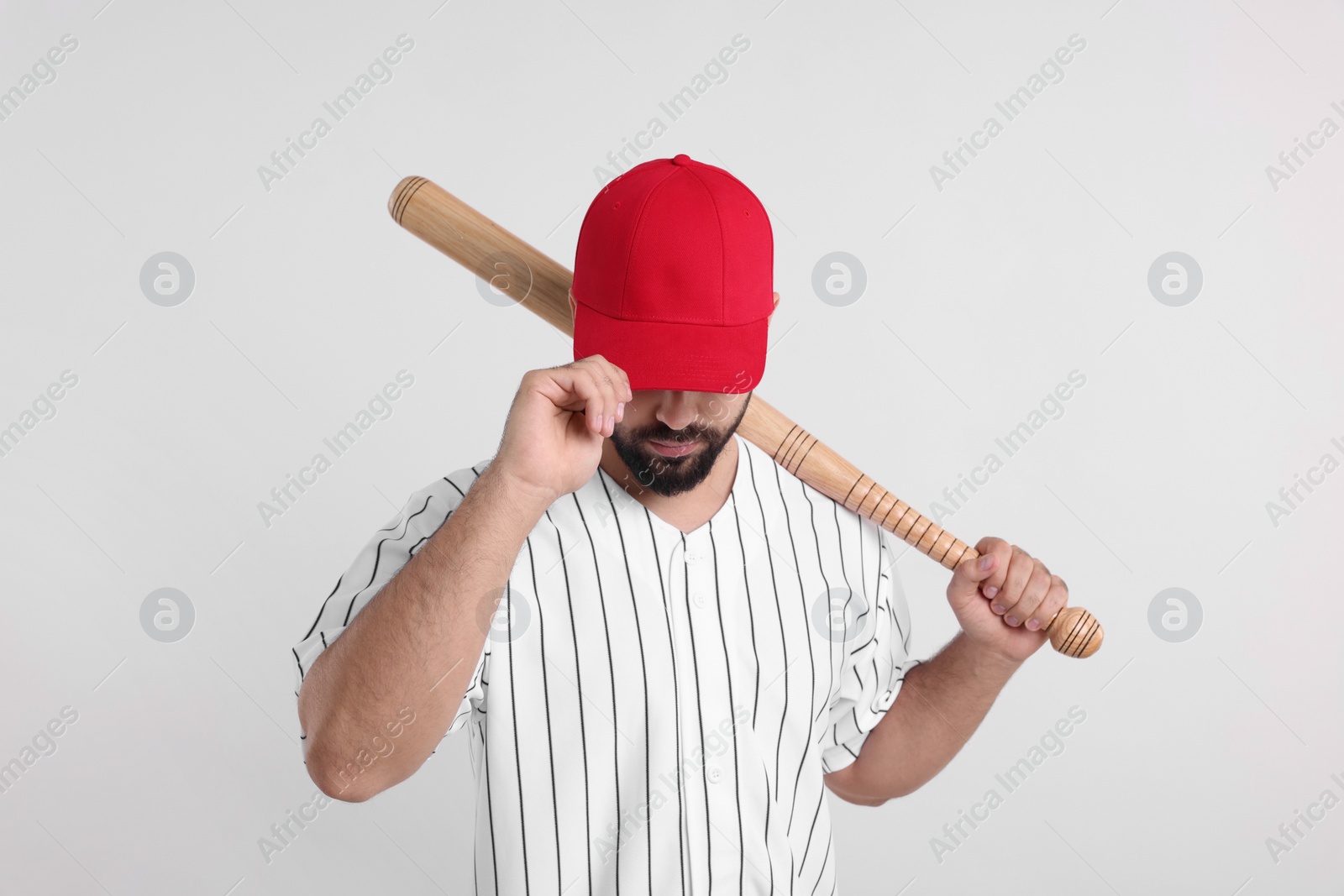 Photo of Man in stylish red baseball cap holding bat on white background