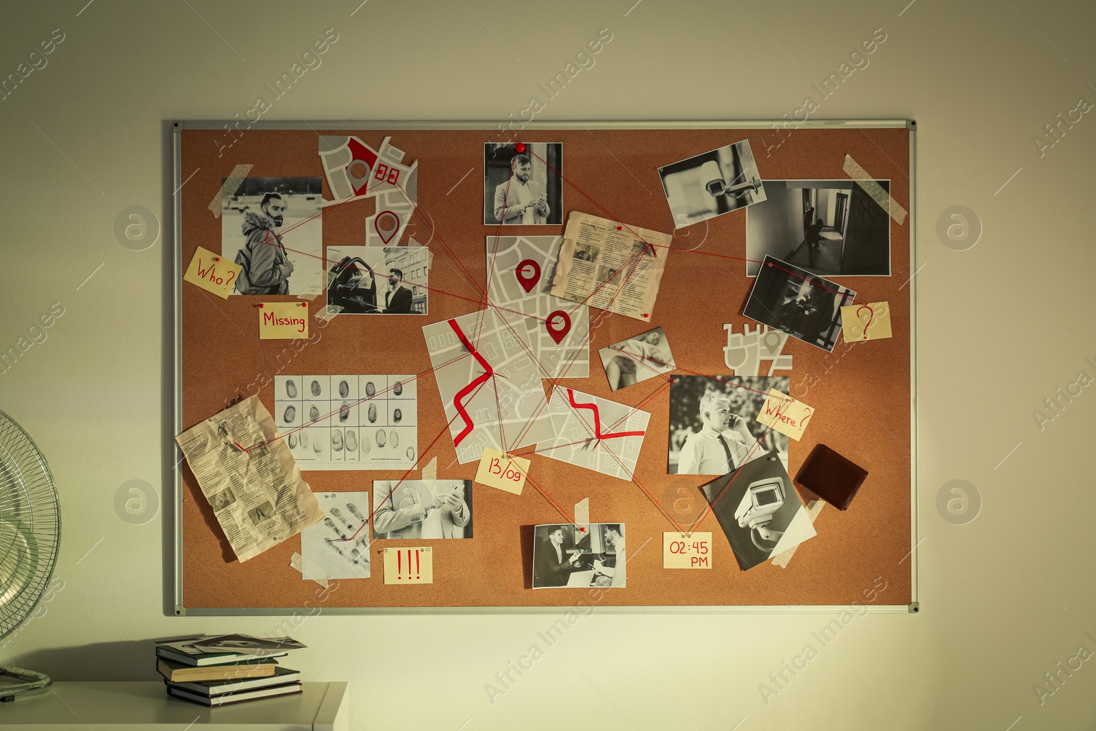 Photo of Detective board with fingerprints, crime scene photos and red threads on white wall in office