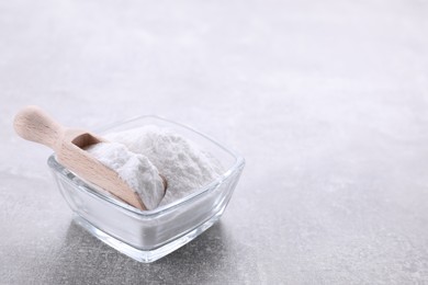 Photo of Bowl of sweet fructose powder on light grey table. Space for text