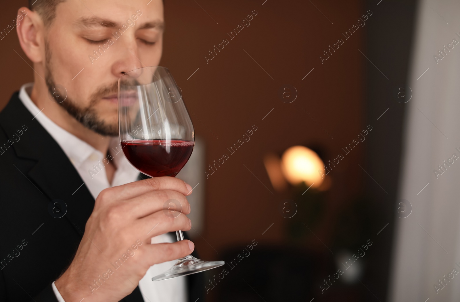 Photo of Young man with glass of wine indoors