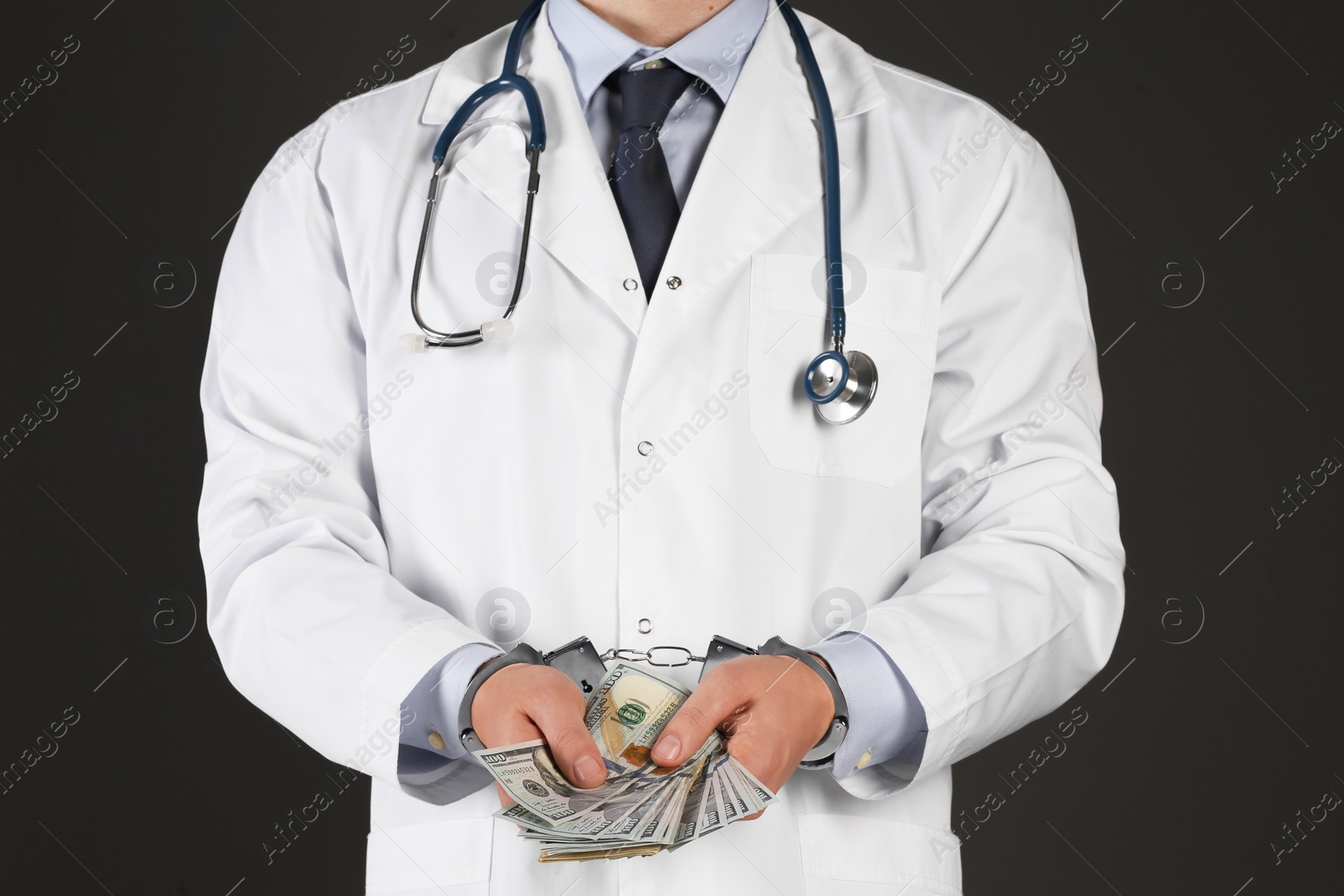 Photo of Doctor in handcuffs with bribe on black background, closeup. Corrupted medicine