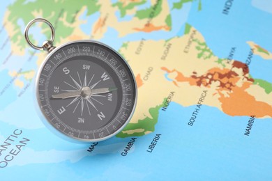 Photo of One compass on world map, space for text. Tourist equipment