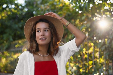 Photo of Portrait of happy young woman in straw hat outdoors on sunny day