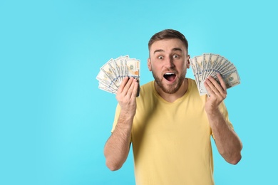 Photo of Portrait of emotional young man with money on color background. Space for text