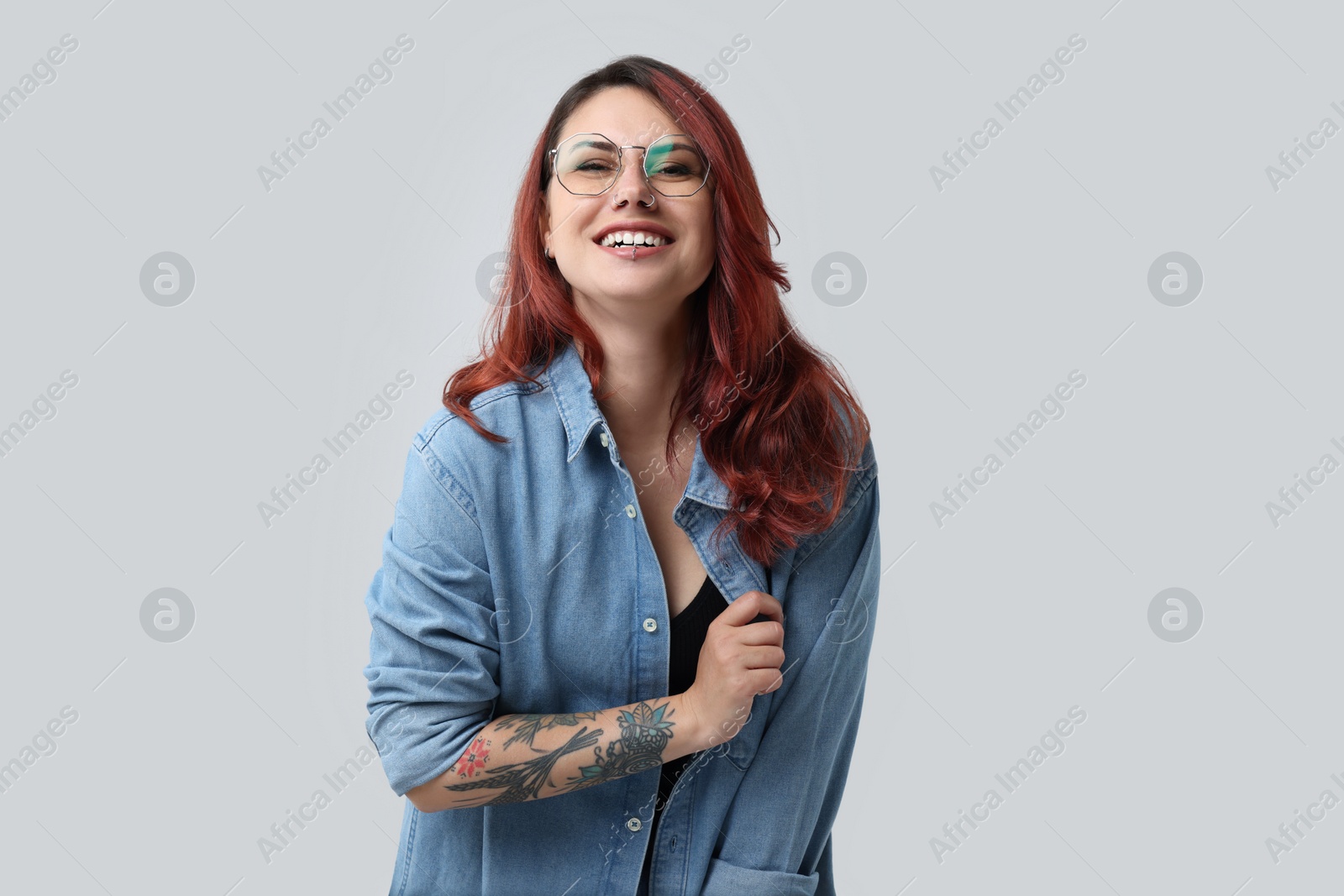 Photo of Portrait of beautiful tattooed woman on gray background