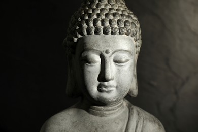 Buddha statue on dark background, closeup view