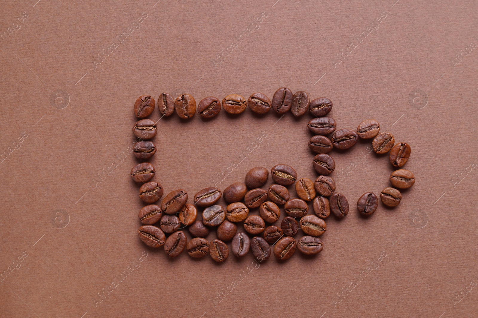 Photo of Cup of drink, composition made with coffee beans on brown background, flat lay