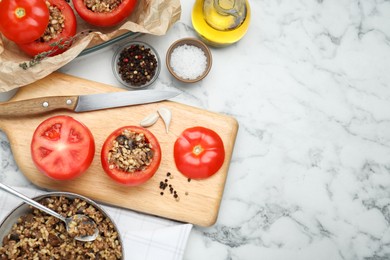 Photo of Preparing stuffed tomatoes with minced beef, bulgur and mushrooms on white marble table, flat lay. Space for text