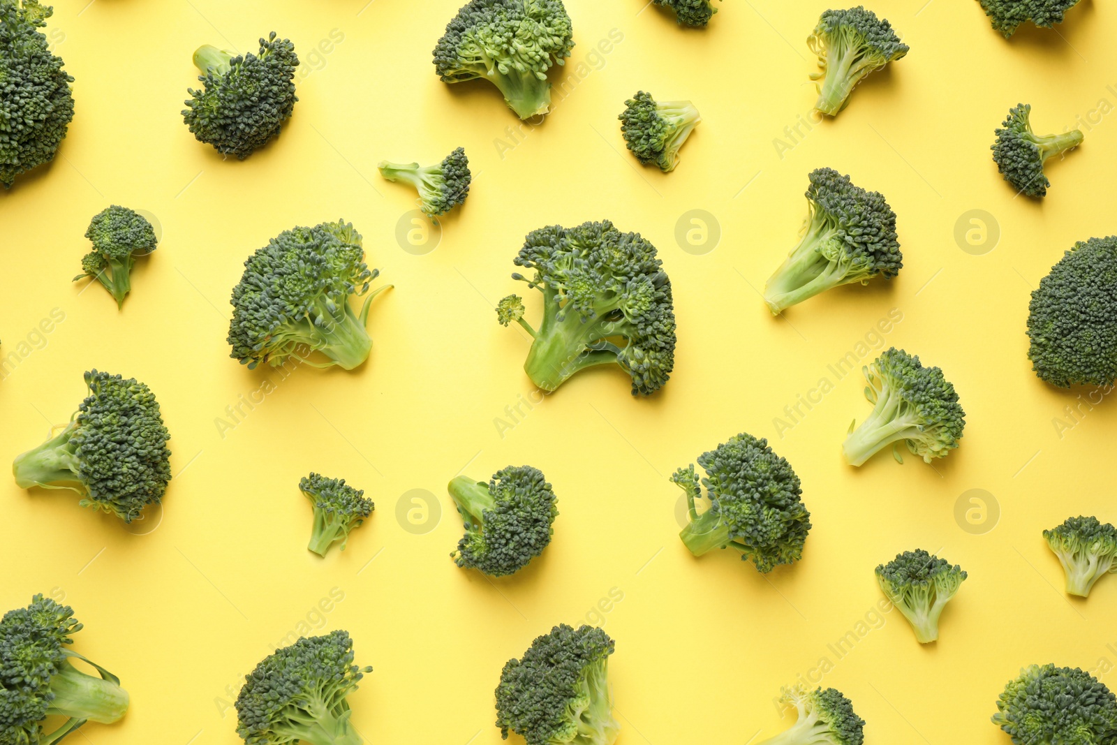 Photo of Fresh tasty broccoli on yellow background, flat lay