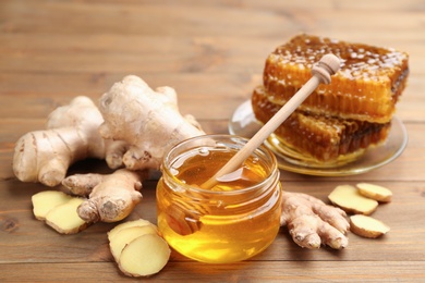 Photo of Honey and ginger on wooden table. Natural cold remedies