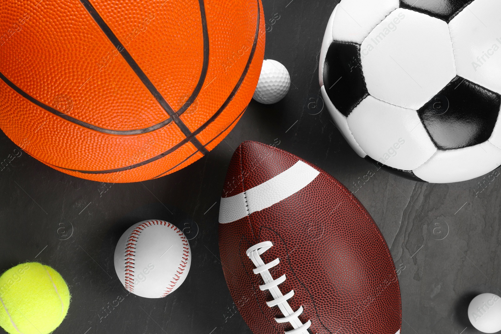 Photo of Many different sports balls on dark gray background, flat lay