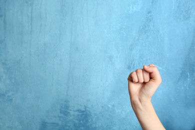 Photo of Woman raising her fist and space for text on color background. Victory concept