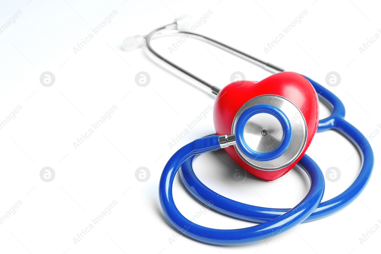 Photo of Stethoscope and heart model on light background. Medical equipment