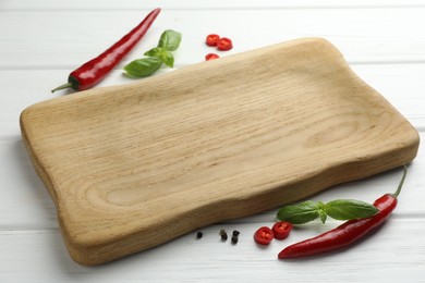 Photo of Cutting board and different spices on white wooden table