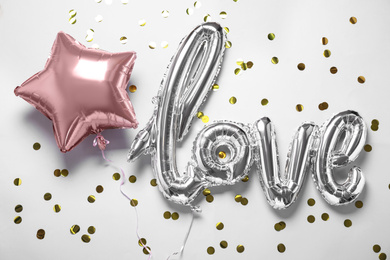 Photo of Foil star shaped and LOVE balloons on white background, above view