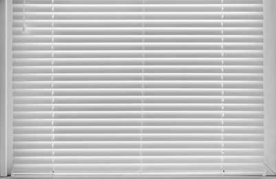 Photo of Stylish window with horizontal blinds in room