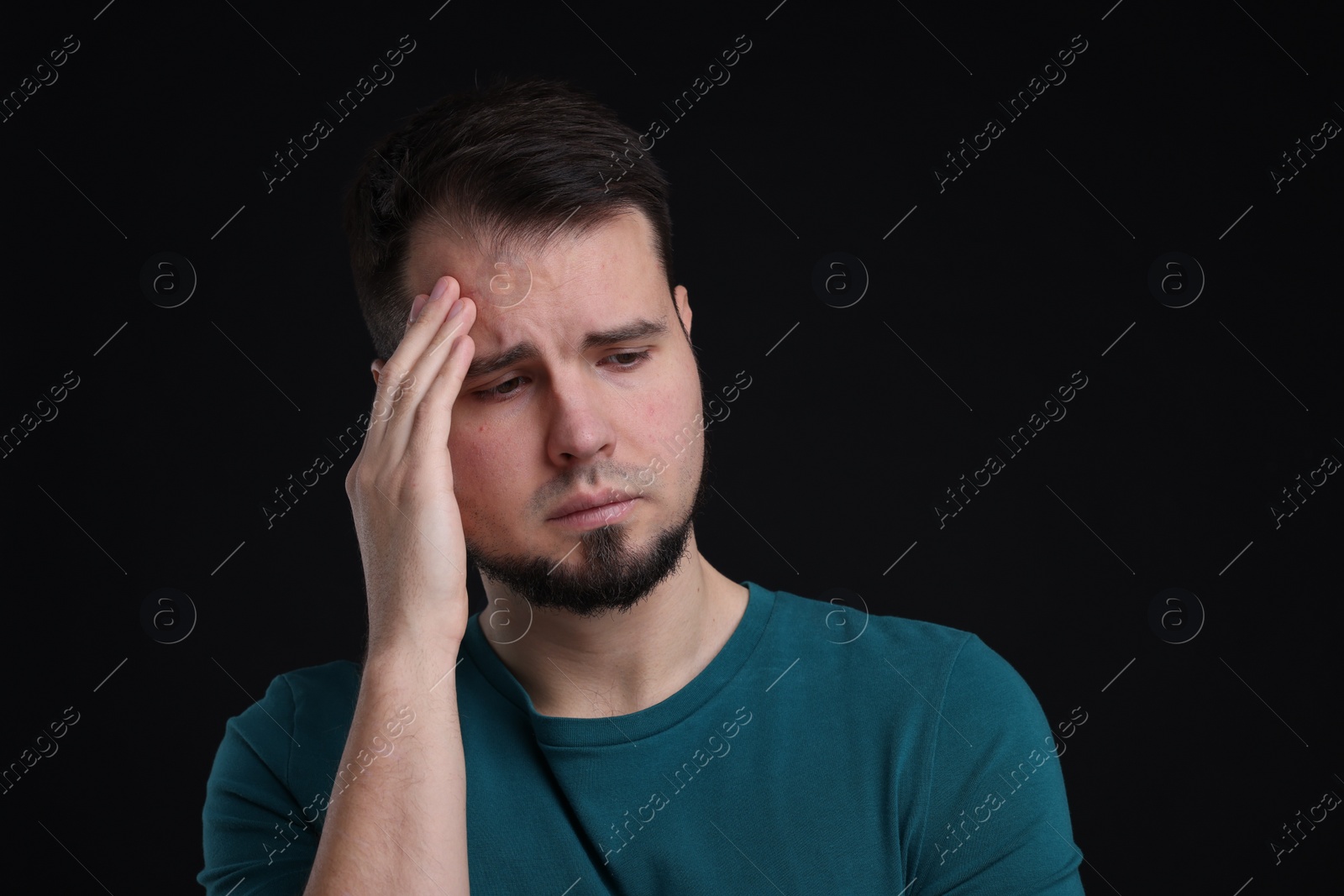 Photo of Portrait of sad man on black background