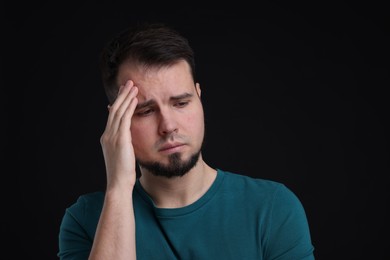 Photo of Portrait of sad man on black background