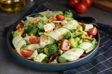 Delicious salad with lentils, vegetables and cheese on grey table