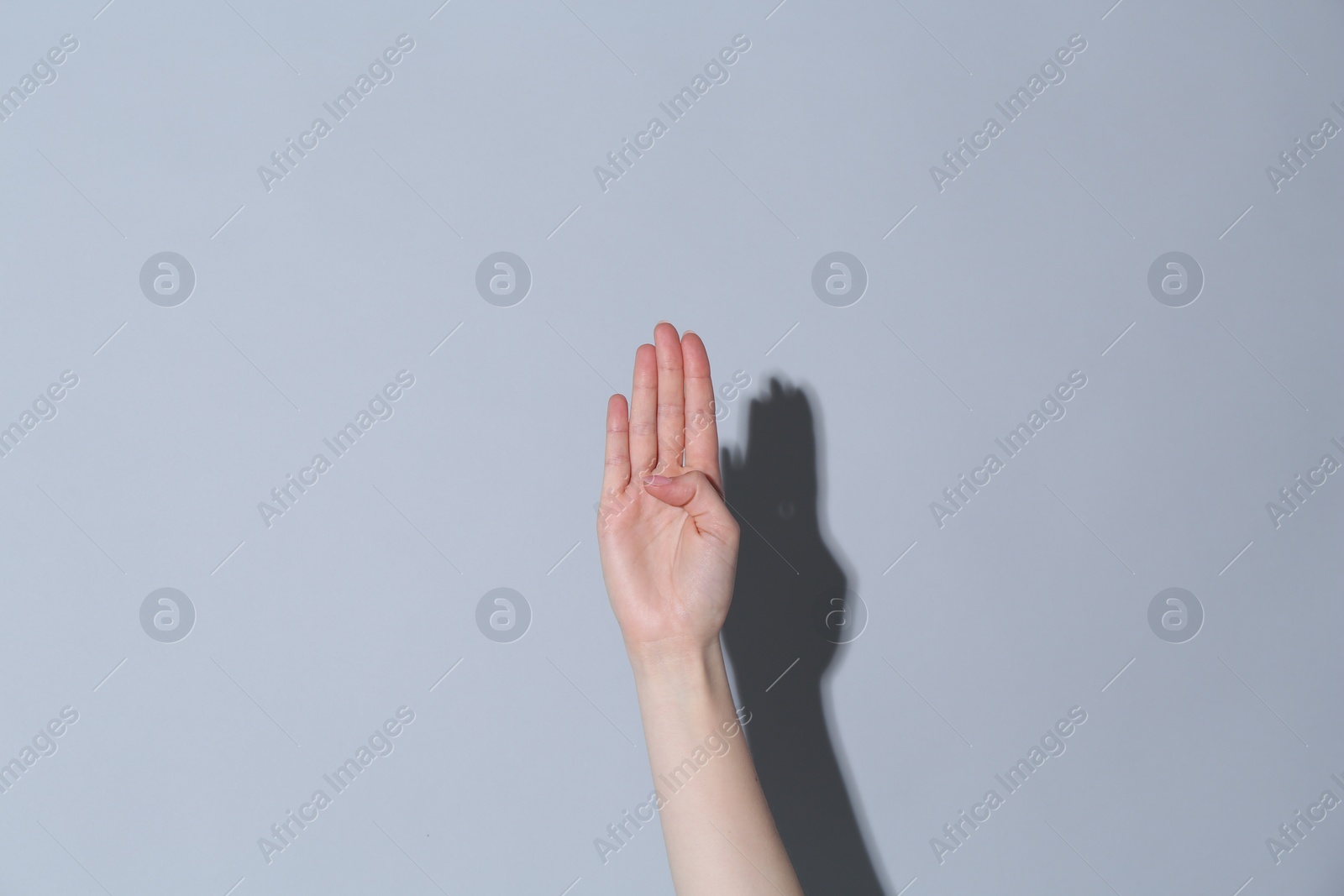 Photo of Woman showing open on light grey background, closeup