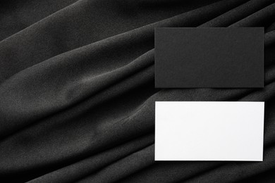 Blank business cards on black fabric, top view. Mockup for design
