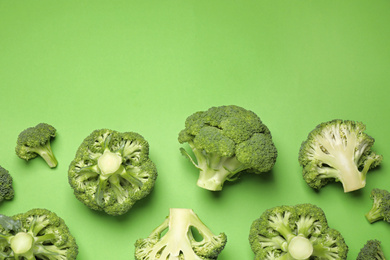 Photo of Fresh broccoli on green background, flat lay. Space for text