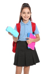 Cute little girl in school uniform with backpack and stationery on white background