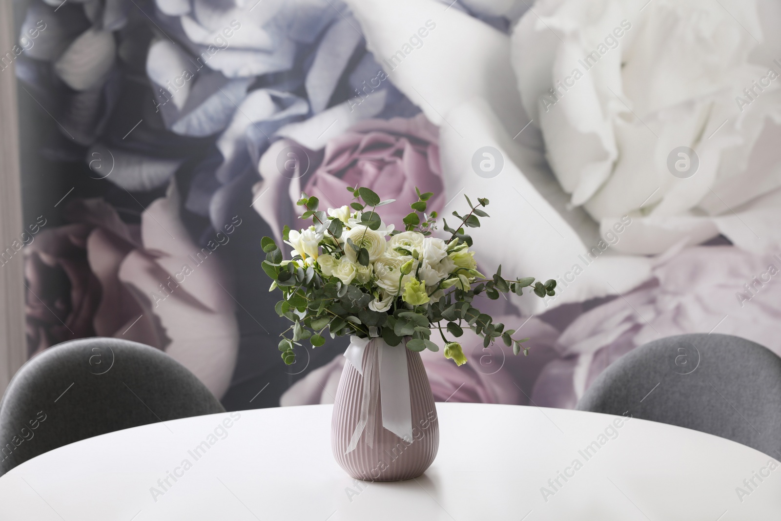 Photo of Vase with beautiful bouquet on white table indoors. Stylish interior element