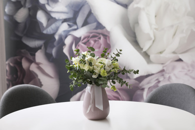 Photo of Vase with beautiful bouquet on white table indoors. Stylish interior element