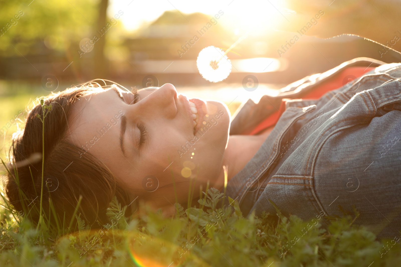 Photo of Young woman with dandelion in park on sunny day. Allergy free concept