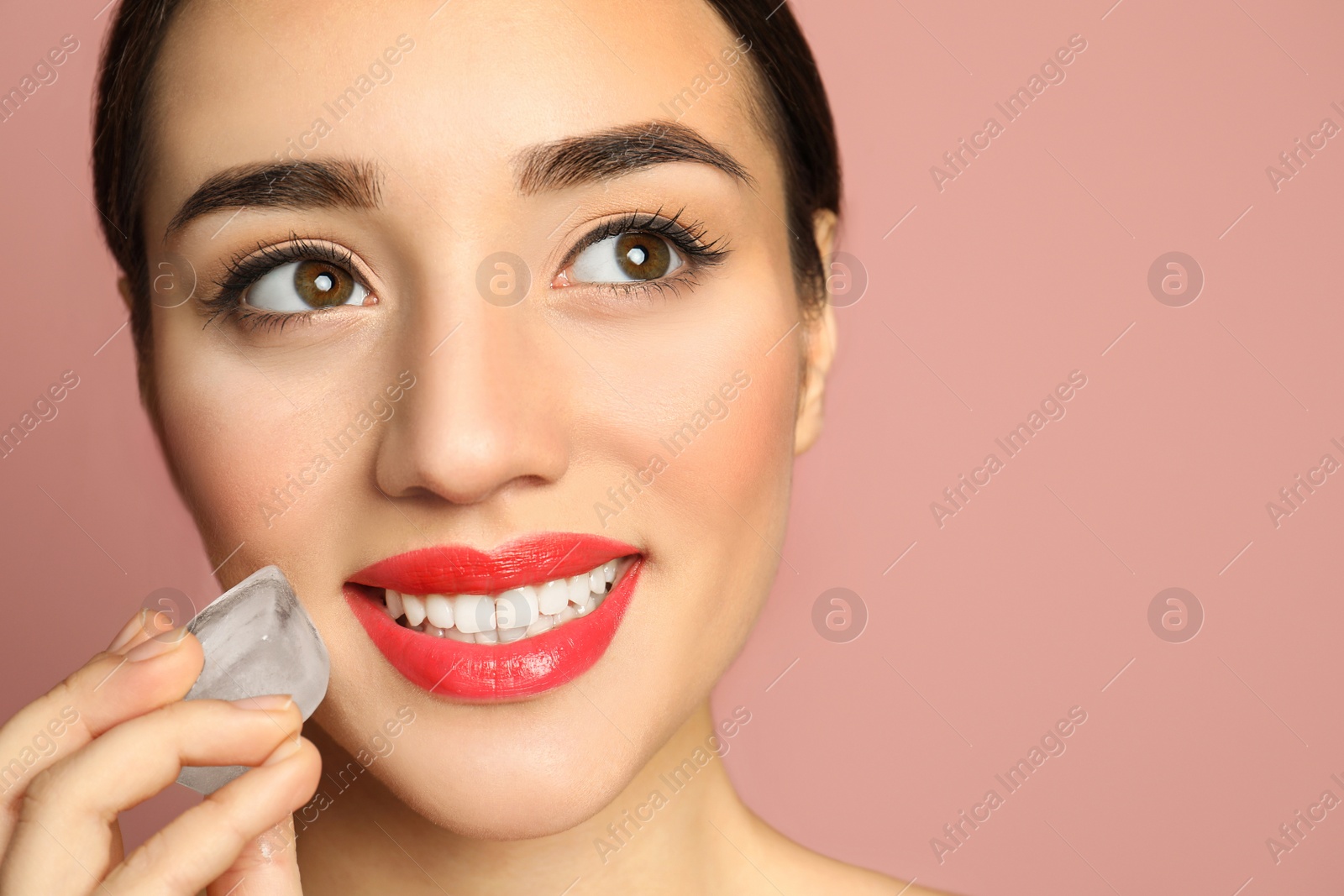 Photo of Young woman with ice cube on color background, space for text. Skin care