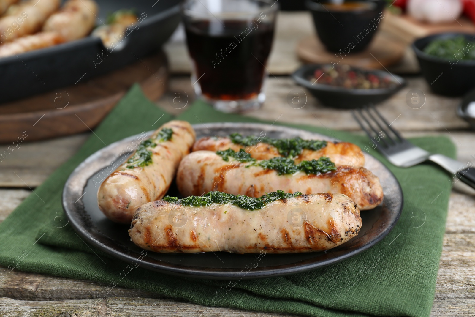 Photo of Tasty fresh grilled sausages with sauce on wooden table
