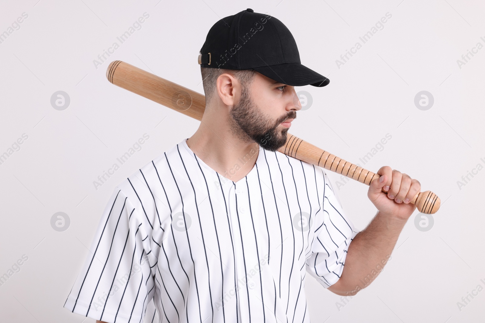 Photo of Man in stylish black baseball cap holding bat on white background