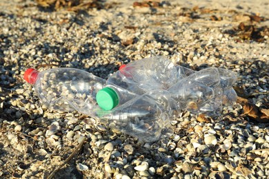 Used plastic bottles on sand outdoors. Environment pollution