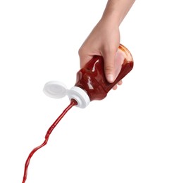 Woman pouring tasty ketchup from bottle isolated on white, closeup