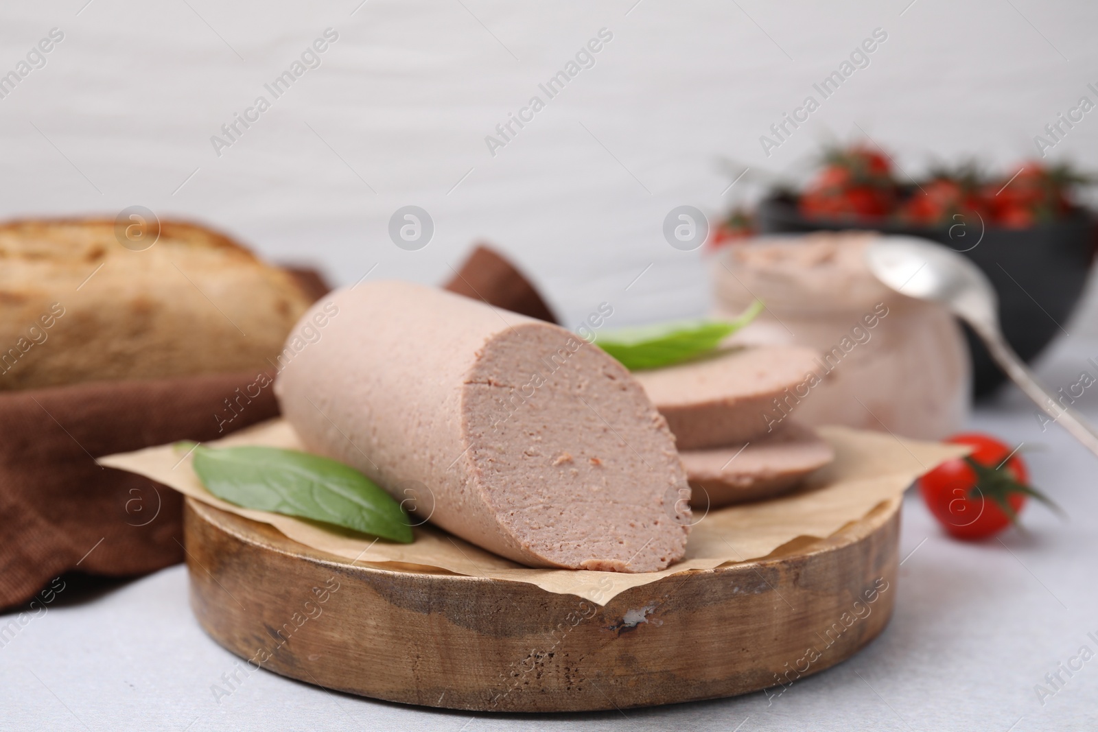 Photo of Delicious liver sausage on light grey table, closeup