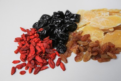 Pile of different dried fruits on white background, closeup