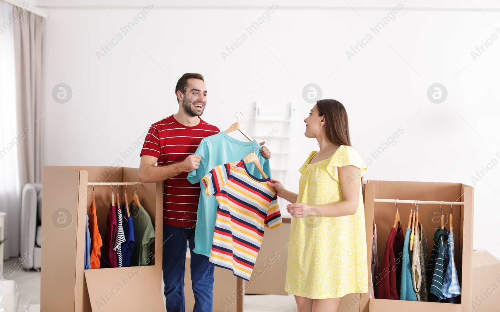 Photo of Young couple near wardrobe boxes at home