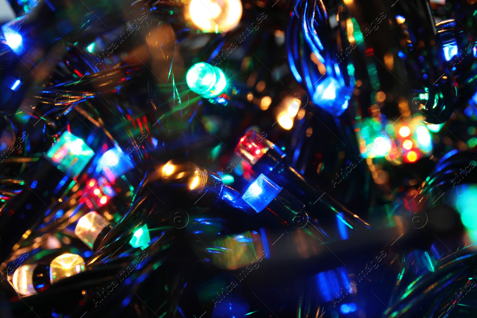 Photo of Beautiful glowing Christmas lights, closeup. Festive illumination