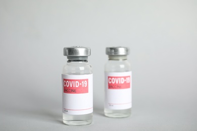 Photo of Vials with coronavirus vaccine on light background