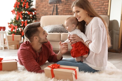 Happy couple with baby celebrating Christmas together at home